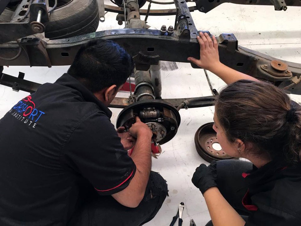 chico y chica en un taller de coches